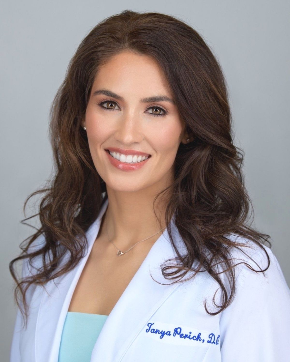 Portrait of a smiling female doctor in white coat.