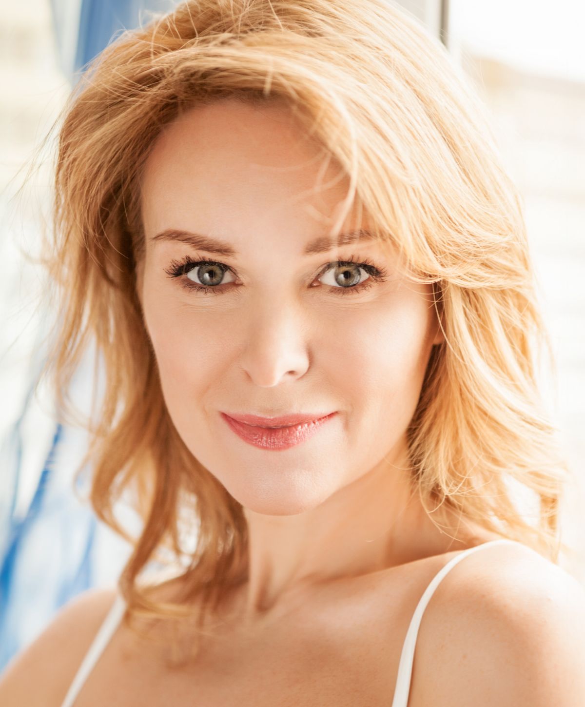 Man in white shirt seated, looking thoughtfully.