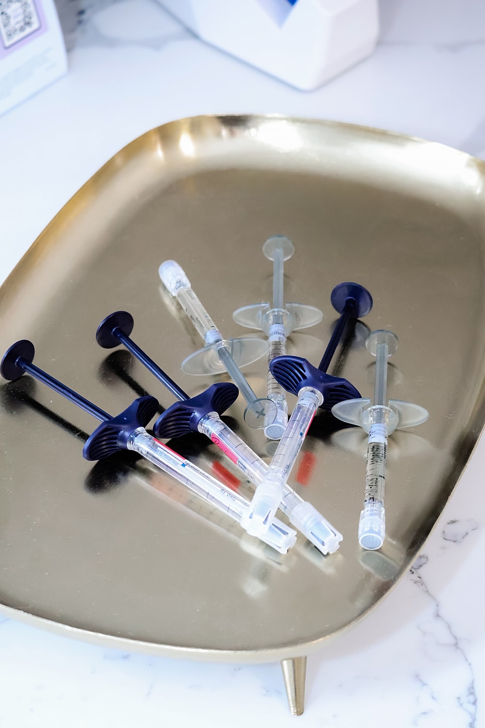 Syringes arranged on a gold tray.