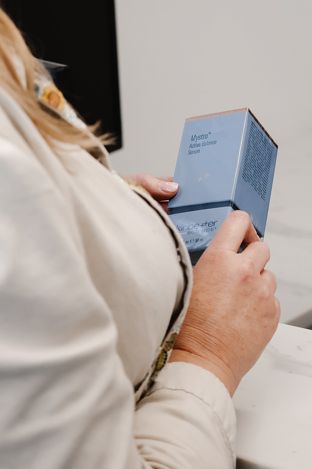 Person holding a skincare serum box.
